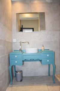 La salle de bains est pourvue d'un lavabo bleu et d'un miroir. dans l'établissement Le ventoux 1912, à Bédoin