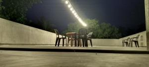 a table and chairs on a patio at night at Ceylon Avenue in Habaraduwa