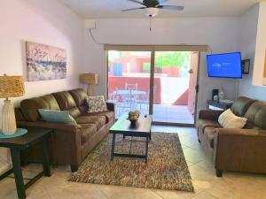 uma sala de estar com um sofá, uma mesa e uma televisão em Sun City Grand Oasis: Luxury Condo Living in La Solana em Surprise