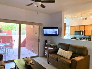 uma sala de estar com um sofá, uma televisão e uma mesa em Sun City Grand Oasis: Luxury Condo Living in La Solana em Surprise