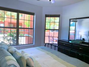 um quarto com uma cama com uma cómoda e janelas em Sun City Grand Oasis: Luxury Condo Living in La Solana em Surprise