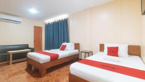 a hotel room with two beds and a couch at RedDoorz at Casa Buena Dormitel Davao City in Davao City