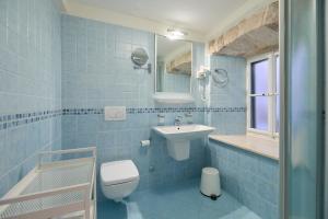 Baño de azulejos azules con aseo y lavamanos en Doria Apartments, en Dubrovnik