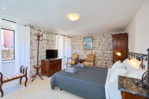 a hotel room with a bed and a tv at Doria Apartments in Dubrovnik