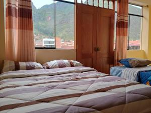 a bedroom with a bed and a large window at Hotel Everest in Pisac