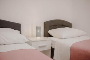 um quarto com 2 camas e uma mesa de cabeceira com um candeeiro em Apartment Martin-nearby Krka National park em Kaočine