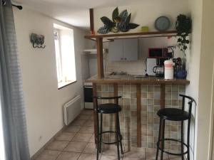 a kitchen with two bar stools and a counter at Normandia Parfum de pommes et d'histoire in Nonant +9 photos