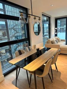 a living room with a wooden table and chairs at Stylist 2 Bedroom Apartment in Central London in London