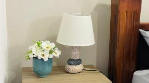 un tavolo con una lampada e un vaso con fiori di Montaña de Paz a San Ramón Sur