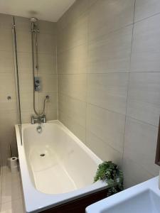 a white bathroom with a tub and a sink at Opulent oasis in London in London