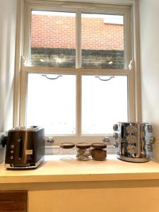 eine Küchentheke mit einem Fenster und einem Toaster in der Unterkunft Opulent oasis in London in London