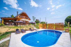 una piscina di fronte a una casa di tronchi di Hižica Bubika a Karlovac