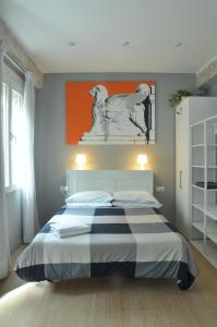1 dormitorio con 1 cama con una pintura naranja en la pared en La Casa Verde - Ruzafa, en Valencia