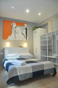 瓦倫西亞的住宿－La Casa Verde - Ruzafa，一间卧室设有两张床,墙上挂有橙色画