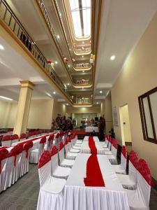 un salón de banquetes con mesas y sillas rojas y blancas en Sơn Nguyên 2, en Hà Tây