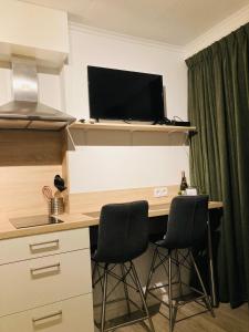 a desk with two chairs and a television on top at Studio Lodo in Middelburg