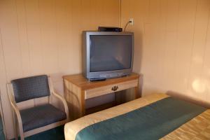 Bel-Air Motel في Alice: تلفزيون صغير وكرسي في الغرفة