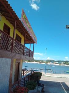 a person sitting on a bench in front of a building at BELAS PRAIAS POUSADA in Alter do Chao