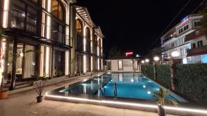 a swimming pool in front of a building at night at Kave Hotels - Pondicherry in Puducherry