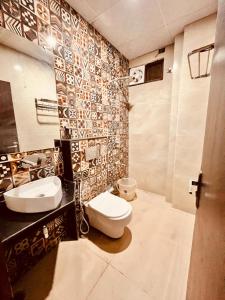 a bathroom with two sinks and a toilet in it at Hotel Ramawati - A Luxury Hotel In Haridwar in Haridwār