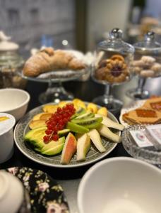 una mesa cubierta con platos de frutas y otros alimentos en B&B Colombo, en Mestre