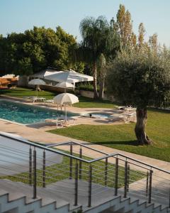uitzicht op een zwembad met parasols bij Hotel Grotta Di Tiberio in Sperlonga