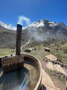 a hot tub with a mountain in the background at hostal el glaciar in Refugio Lo Valdés