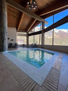 a swimming pool in a house with windows at hostal el glaciar in Refugio Lo Valdés
