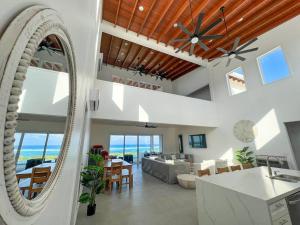 sala de estar con espejo y sala de estar con vistas al océano en Casa Blanca Camp Bay Estates, en Camp Bay