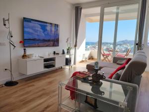 a living room with a tv and a couch at LMCM Canteras in Las Palmas de Gran Canaria