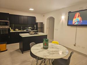 a kitchen with a table and a tv on the wall at DEPARTAMENTO SAME CASA BLANCa in Same