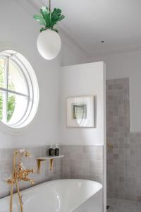 een witte badkamer met een bad en een raam bij Gregans Castle Hotel in Ballyvaughan