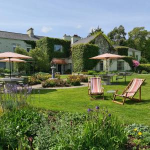 巴利沃恩的住宿－Gregans Castle Hotel，花园内两把草坪椅和遮阳伞