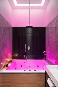 MAIN - Duomo في نابولي: حوض استحمام وردي في الحمام مع إضاءة وردية