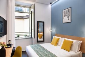 um quarto com uma cama com almofadas amarelas e uma janela em MAIN - Duomo em Nápoles