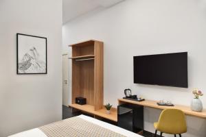 a bedroom with a desk and a tv on a wall at MAIN - Duomo in Naples