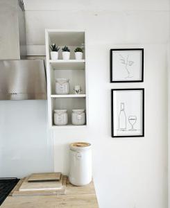 a white kitchen with white shelves and plants at Seaview 2 bedroom apartment in Littlehampton