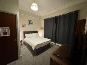 a small bedroom with a bed and a window at Guesthouse 24-7 The Old Knoll Guesthouse in Newport