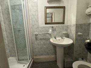 a bathroom with a sink and a shower at Guesthouse 24-7 The Old Knoll Guesthouse in Newport