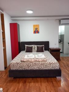 a bedroom with a bed with two towels on it at Apartmani Pause in Niš