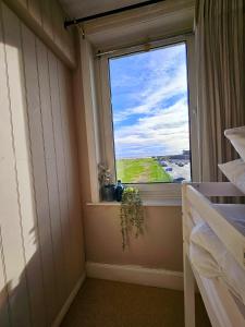 a window in a bedroom with a view of the ocean at Seaview 2 bedroom apartment in Littlehampton
