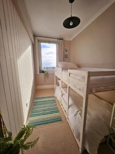 a small room with two bunk beds and a window at Seaview 2 bedroom apartment in Littlehampton