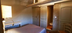 a bedroom with a bed and a lamp and a closet at Chambres & Tables d'hôtes Moulin de Lavon in Gargas