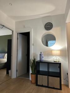 a living room with a table and a clock on the wall at Modern City Centre Apartment in Dublin