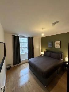 a bedroom with a bed and a large window at Modern City Centre Apartment in Dublin