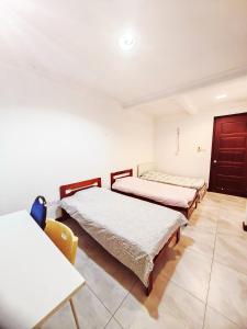 um quarto com três camas e uma mesa em Vivacity Staycation Home 6 Bedrooms em Kuching