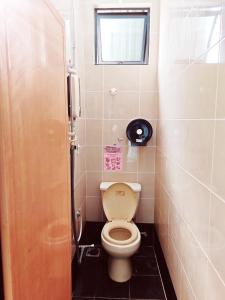 uma pequena casa de banho com um WC e uma janela em Vivacity Staycation Home 6 Bedrooms em Kuching