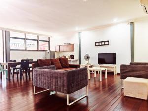 uma sala de estar com um sofá e uma sala de jantar em Vivacity Staycation Home 6 Bedrooms em Kuching