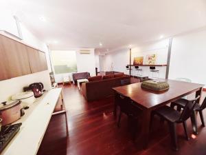 uma sala de estar com uma mesa e um sofá em Vivacity Staycation Home 6 Bedrooms em Kuching