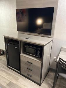 a entertainment center with a tv and a microwave at The Wayne Inn in Wayne